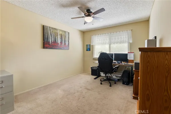 a view of a workspace with furniture and a window