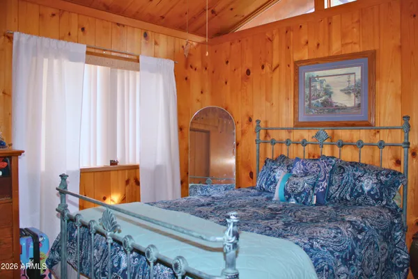 a bedroom with bed and wooden floor