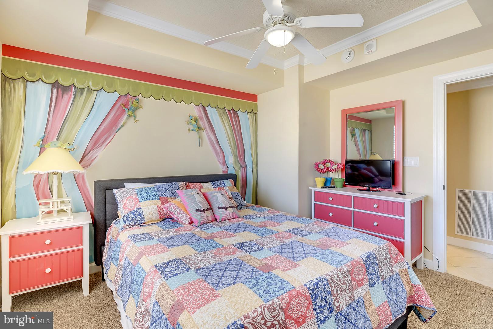 4601 Coastal Highway, Unit 403 Ocean City, MD 21842 - Photo 27 of 56 a bedroom with a bed and a chandelier