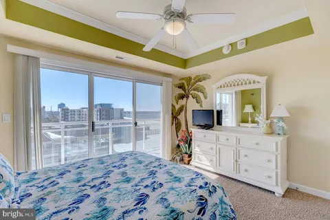 a bedroom with a large bed and a flat tv screen on dresser