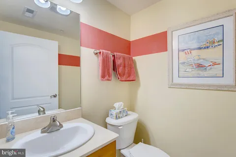 a bathroom with a sink vanity mirror and toilet