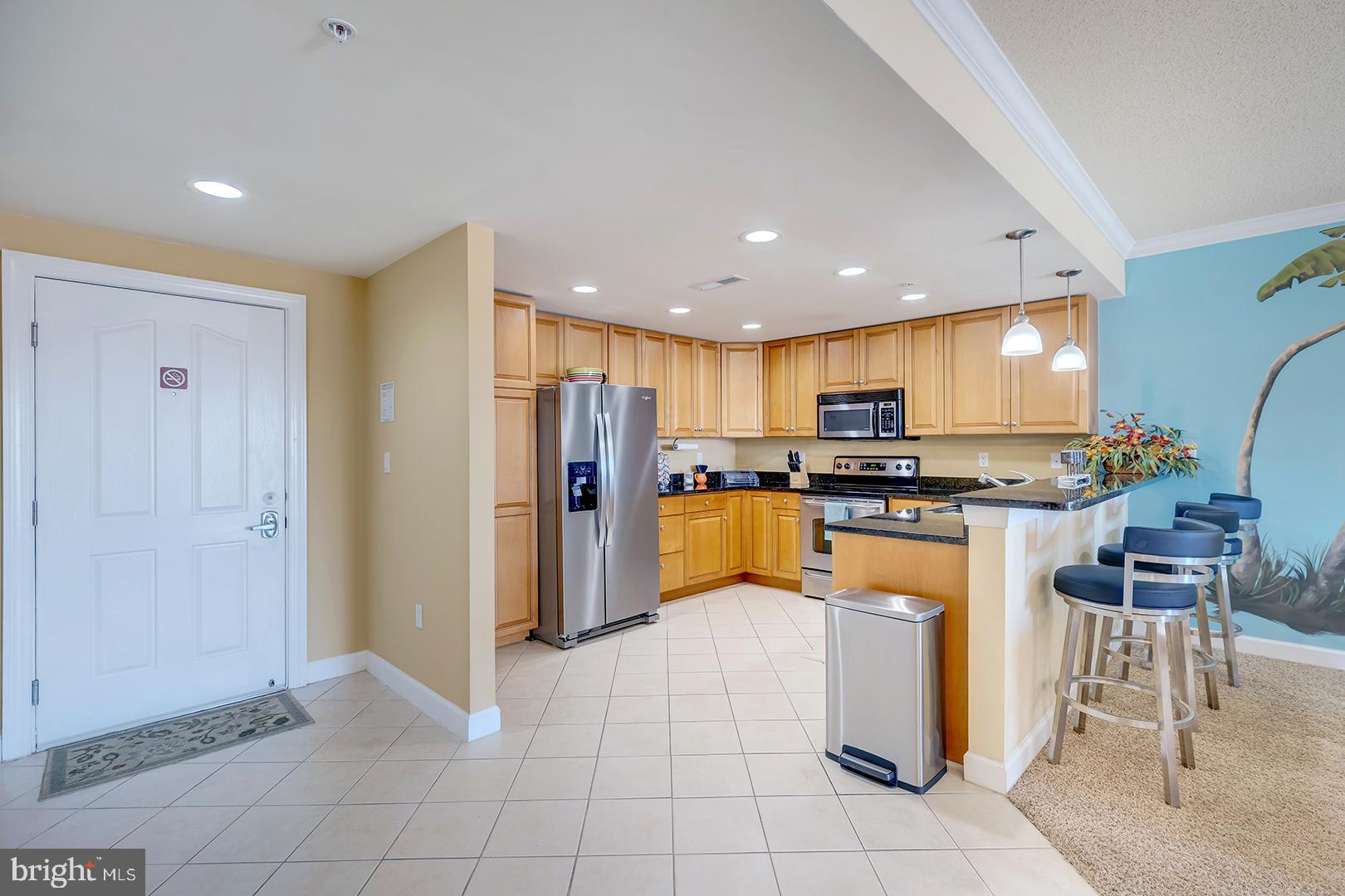 4601 Coastal Highway, Unit 403 Ocean City, MD 21842 - Photo 4 of 56 a kitchen with stainless steel appliances granite countertop a refrigerator and a stove top oven