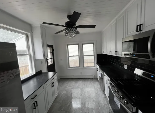 a kitchen with granite countertop a stove a sink and a microwave