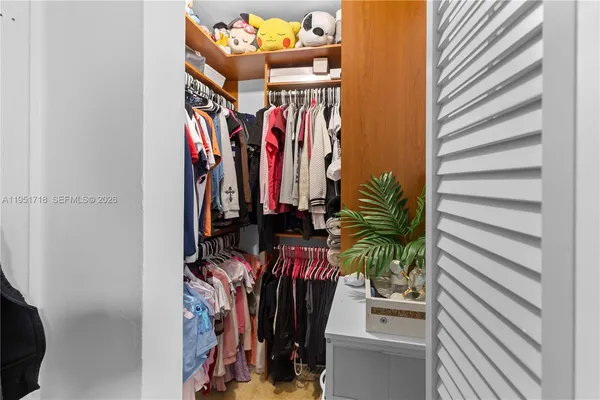 a view of walk in closet with clothes
