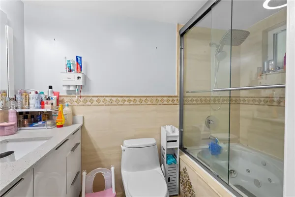 a bathroom with a granite countertop sink a toilet and a shower