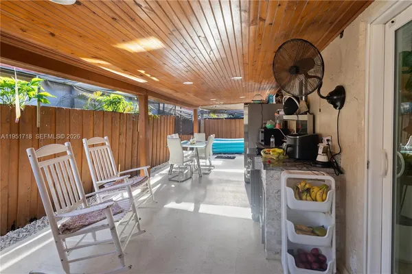a view of a dining room with furniture one side kitchen view and a large window