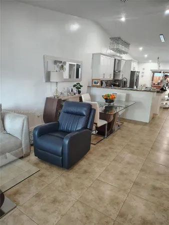 a living room with furniture and a view of kitchen