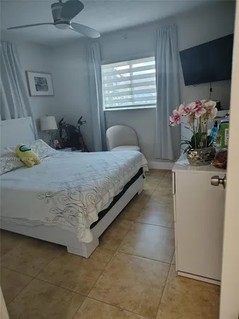 a bedroom with a bed and a potted plant