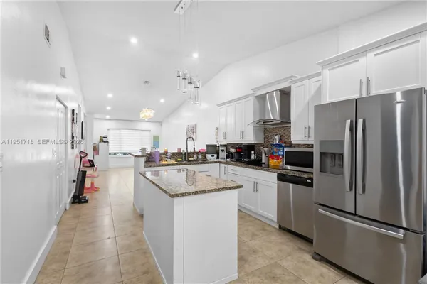 a kitchen with refrigerator a sink and a counter top space