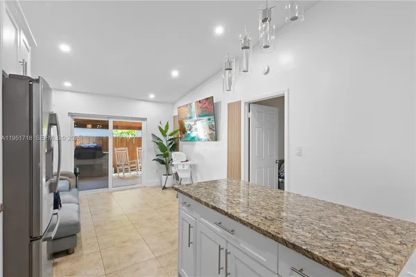 a kitchen with stainless steel appliances granite countertop a sink and a refrigerator