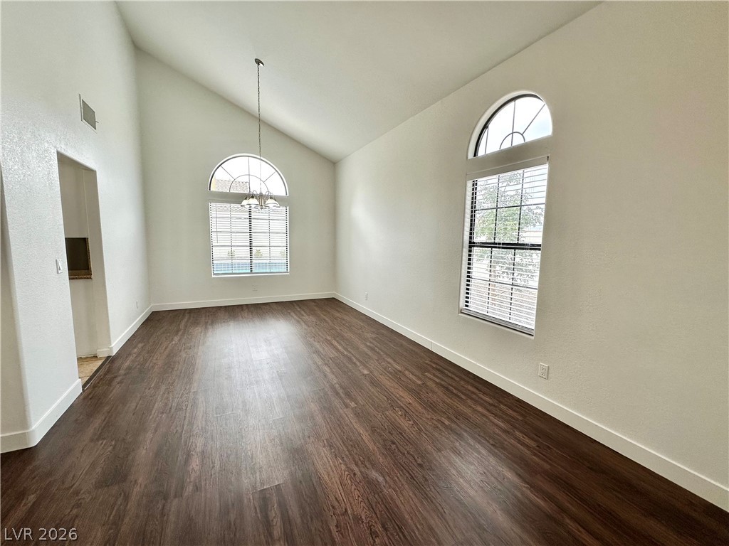 2113 Rico Peak Court Las Vegas, NV 89128 - Photo 15 of 53 Unfurnished room with vaulted ceiling, dark wood-style floors, and a chandelier