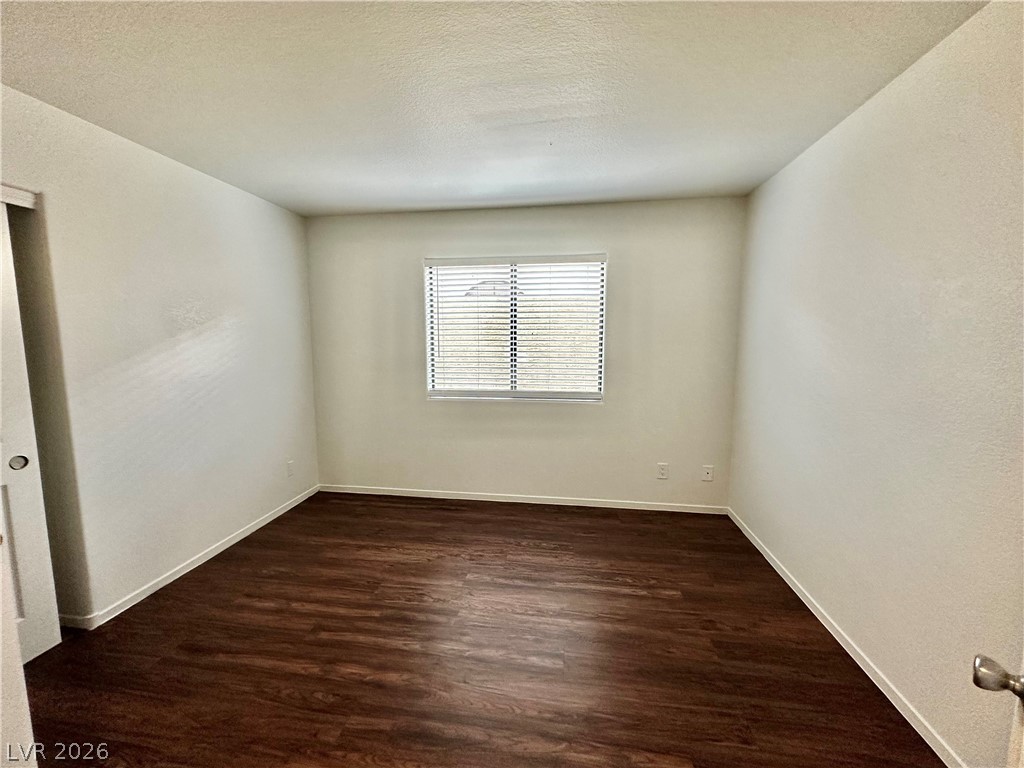 2113 Rico Peak Court Las Vegas, NV 89128 - Photo 20 of 53 Unfurnished room with dark wood finished floors, a textured wall, and a textured ceiling