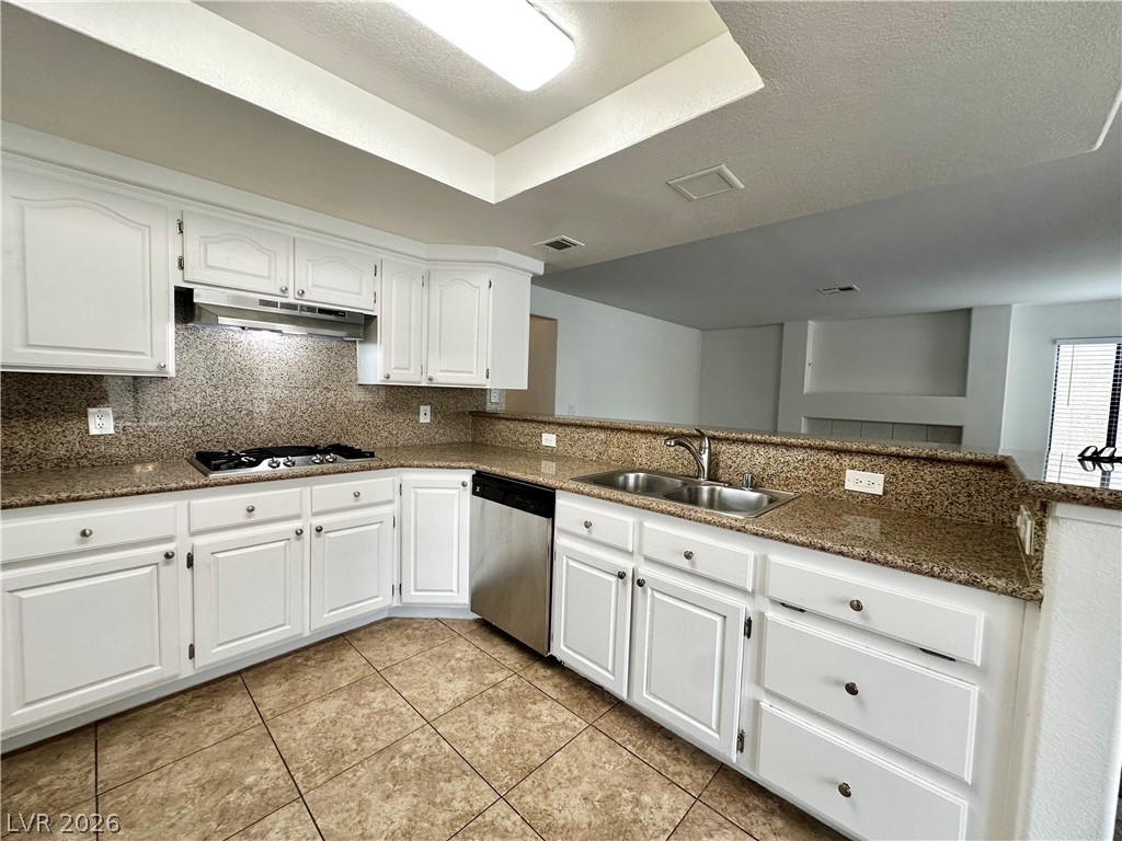 2113 Rico Peak Court Las Vegas, NV 89128 - Photo 27 of 53 Kitchen featuring white cabinetry, stainless steel dishwasher, decorative backsplash, light tile patterned flooring, and a textured ceiling