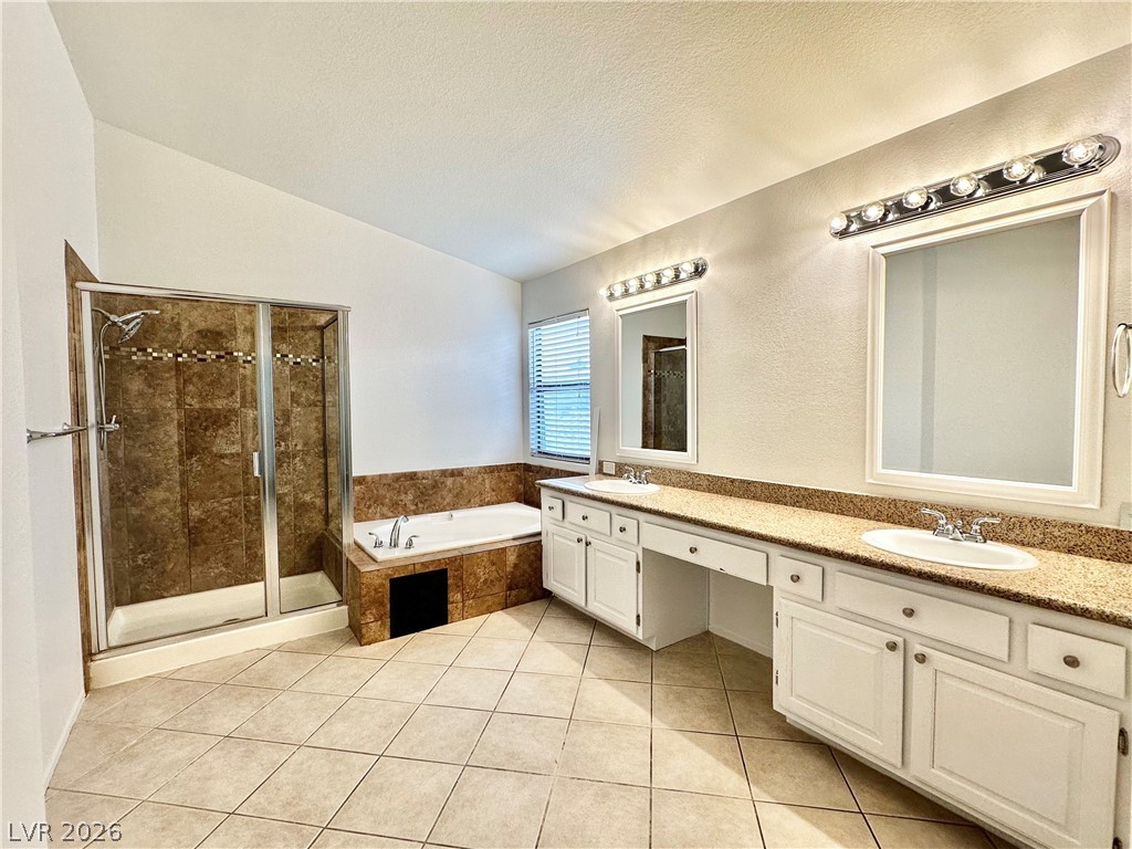 2113 Rico Peak Court Las Vegas, NV 89128 - Photo 28 of 53 Bathroom featuring a shower stall, a garden tub, double vanity, and light tile patterned flooring
