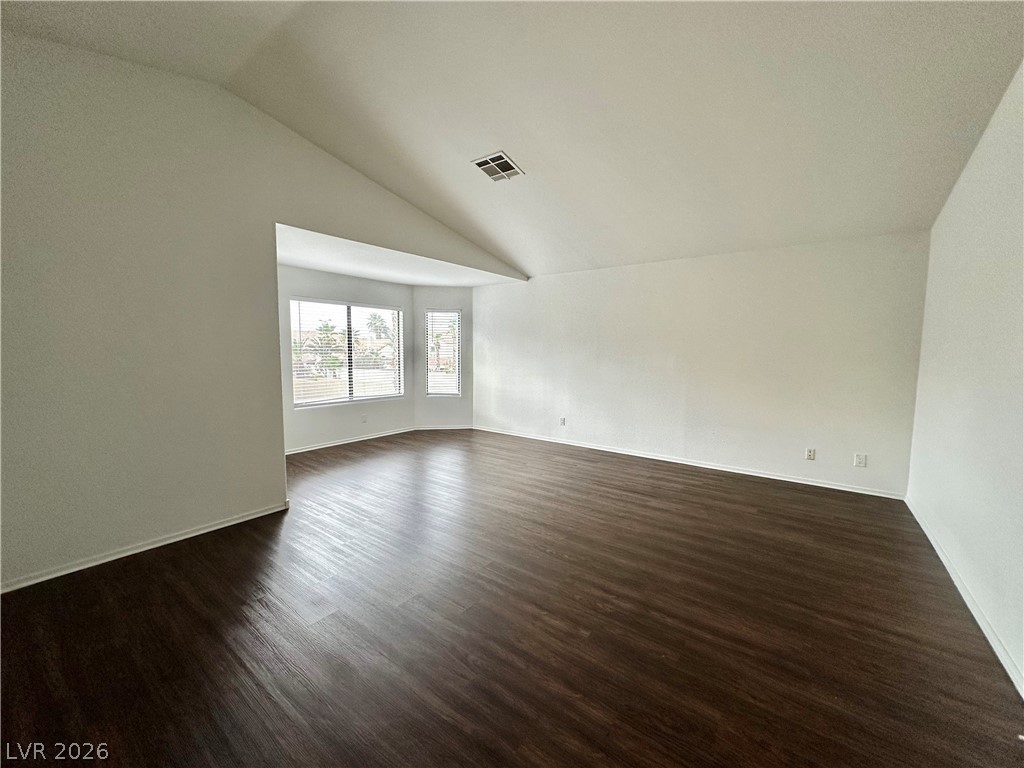 2113 Rico Peak Court Las Vegas, NV 89128 - Photo 33 of 53 Unfurnished room with dark wood-style floors and vaulted ceiling