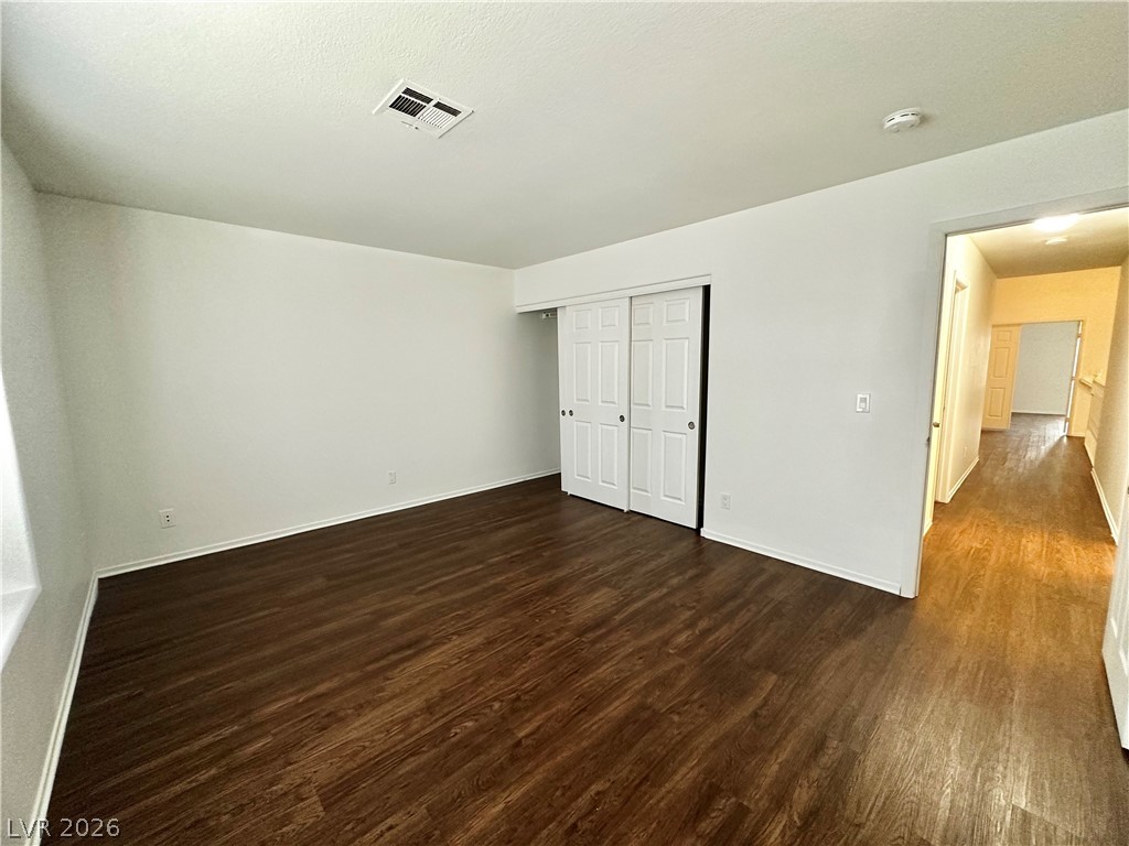 2113 Rico Peak Court Las Vegas, NV 89128 - Photo 38 of 53 Unfurnished bedroom featuring dark wood finished floors and a closet