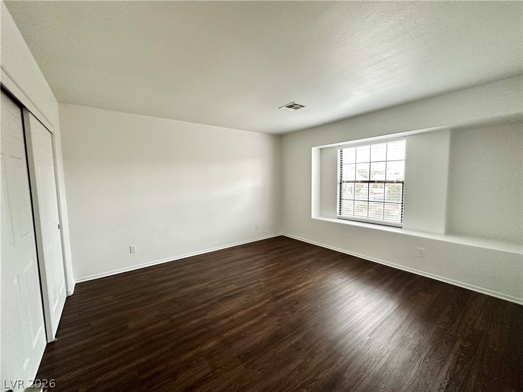 2113 Rico Peak Court Las Vegas, NV 89128 - Photo 39 of 53 Unfurnished bedroom with dark wood-style floors, a closet, and a textured ceiling