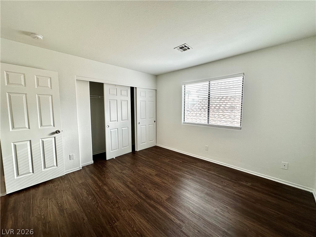 2113 Rico Peak Court Las Vegas, NV 89128 - Photo 41 of 53 Unfurnished bedroom featuring dark wood-style flooring and a closet