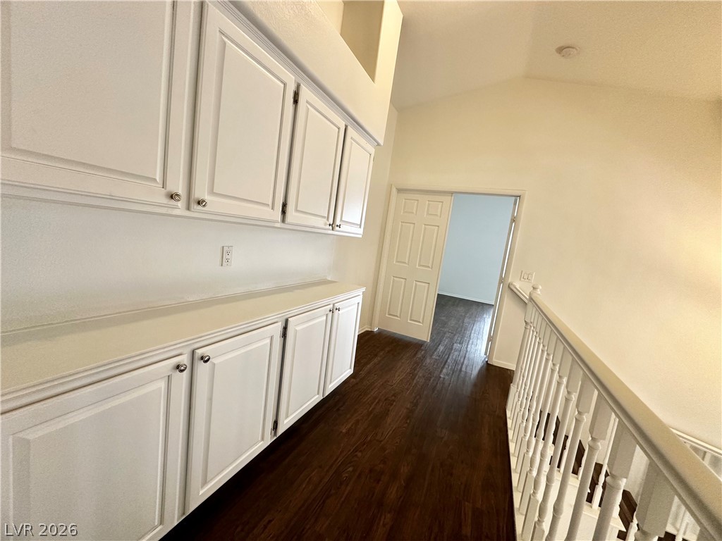 2113 Rico Peak Court Las Vegas, NV 89128 - Photo 42 of 53 Corridor featuring dark wood-style floors, lofted ceiling, and an upstairs landing