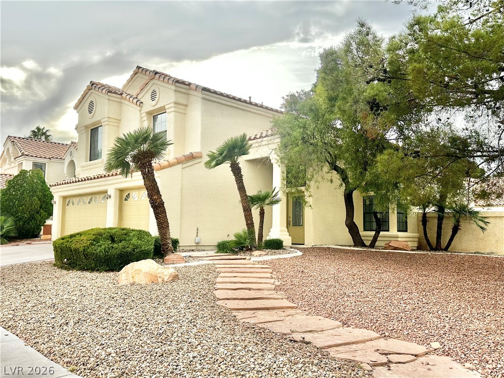 2113 Rico Peak Court Las Vegas, NV 89128 - Photo 51 of 53 View of front facade featuring an attached garage, stucco siding, driveway, and a tiled roof