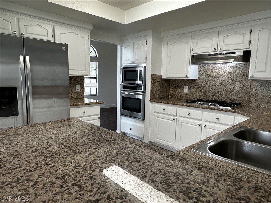 2113 Rico Peak Court Las Vegas, NV 89128 - Photo 6 of 53 Kitchen with stainless steel appliances, white cabinets, and tasteful backsplash