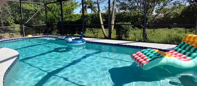 a backyard of a house with table and chairs under an umbrella