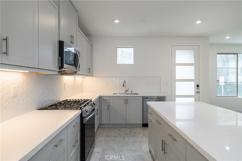194 Abacus Irvine, CA 92618 - Photo 12 of 34 a kitchen with a sink stove top oven and cabinets