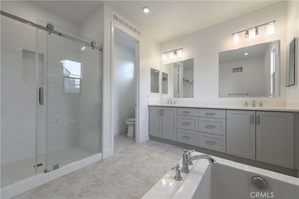 194 Abacus Irvine, CA 92618 - Photo 20 of 34 a spacious bathroom with a shower sink double and mirror