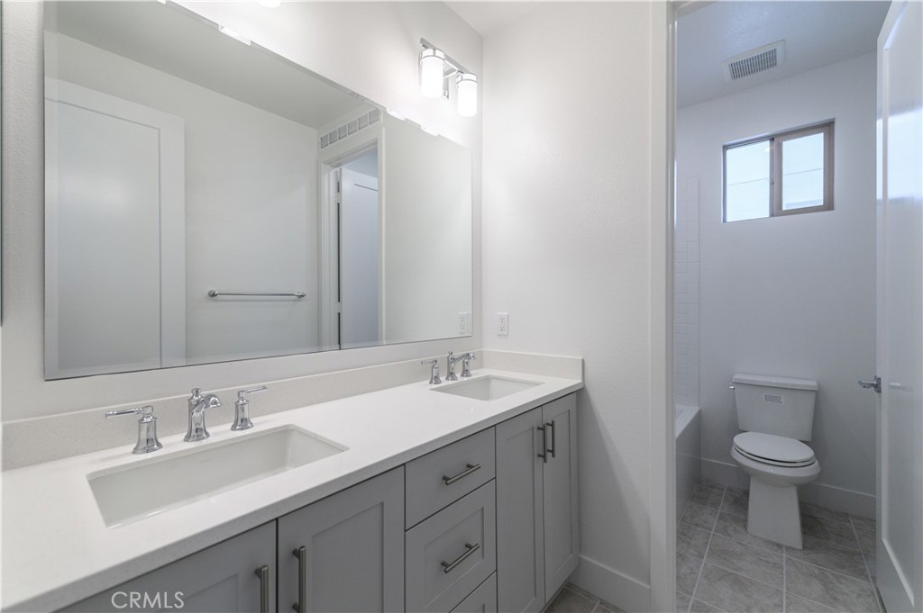 194 Abacus Irvine, CA 92618 - Photo 23 of 34 a bathroom with a granite countertop sink a toilet and a mirror