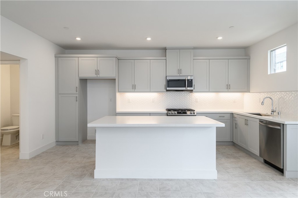 194 Abacus Irvine, CA 92618 - Photo 10 of 34 a kitchen with stainless steel appliances granite countertop a stove top oven a sink and white cabinets