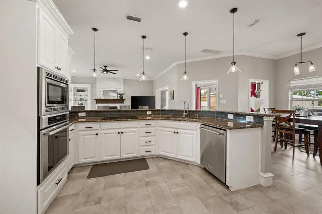 a kitchen with granite countertop a stove microwave and cabinets
