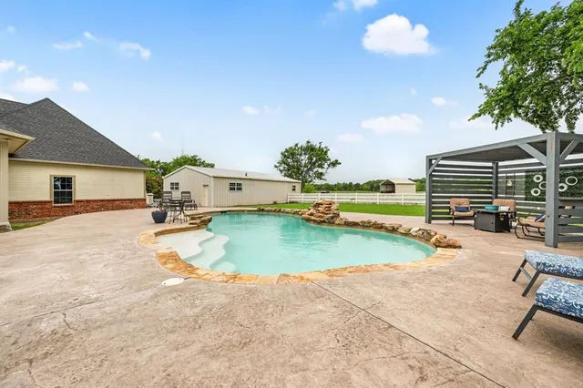 a view of swimming pool with outdoor seating and garden