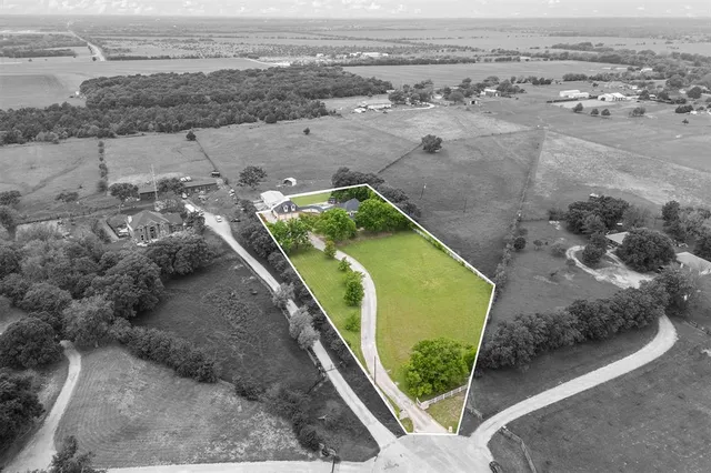 an aerial view of a house with a yard and lake view