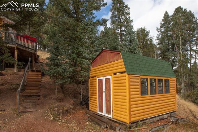 361 Willow Road Divide, CO 80814 - Photo 25 of 27 View of shed featuring stairs and view of wooded area