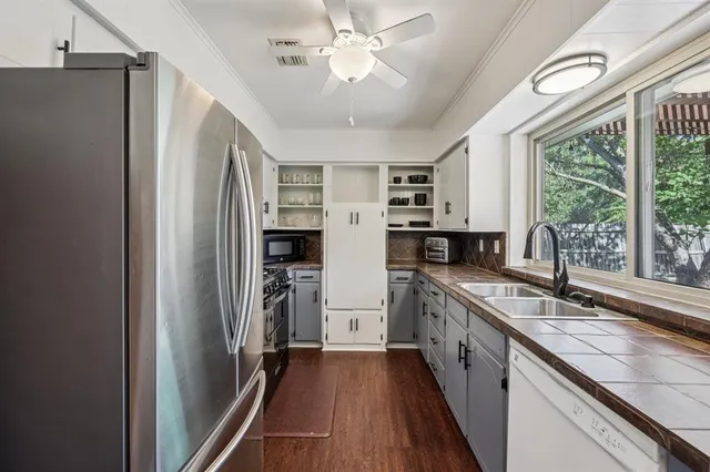 a kitchen with stainless steel appliances granite countertop a refrigerator and a sink
