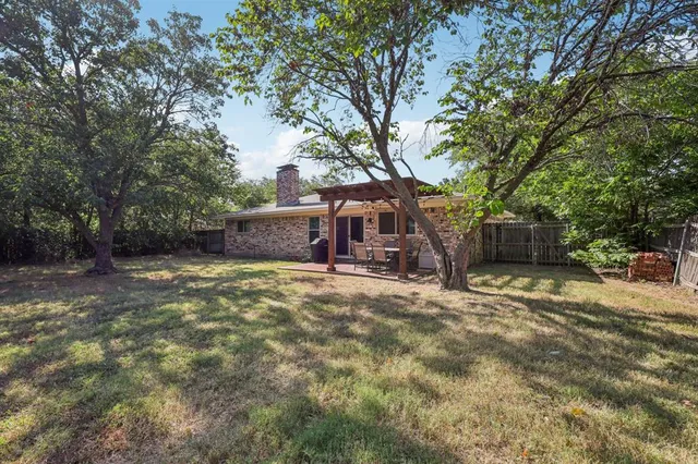 a view of a house with backyard and a tree