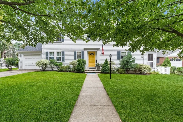 a front view of a house with a yard and potted plants