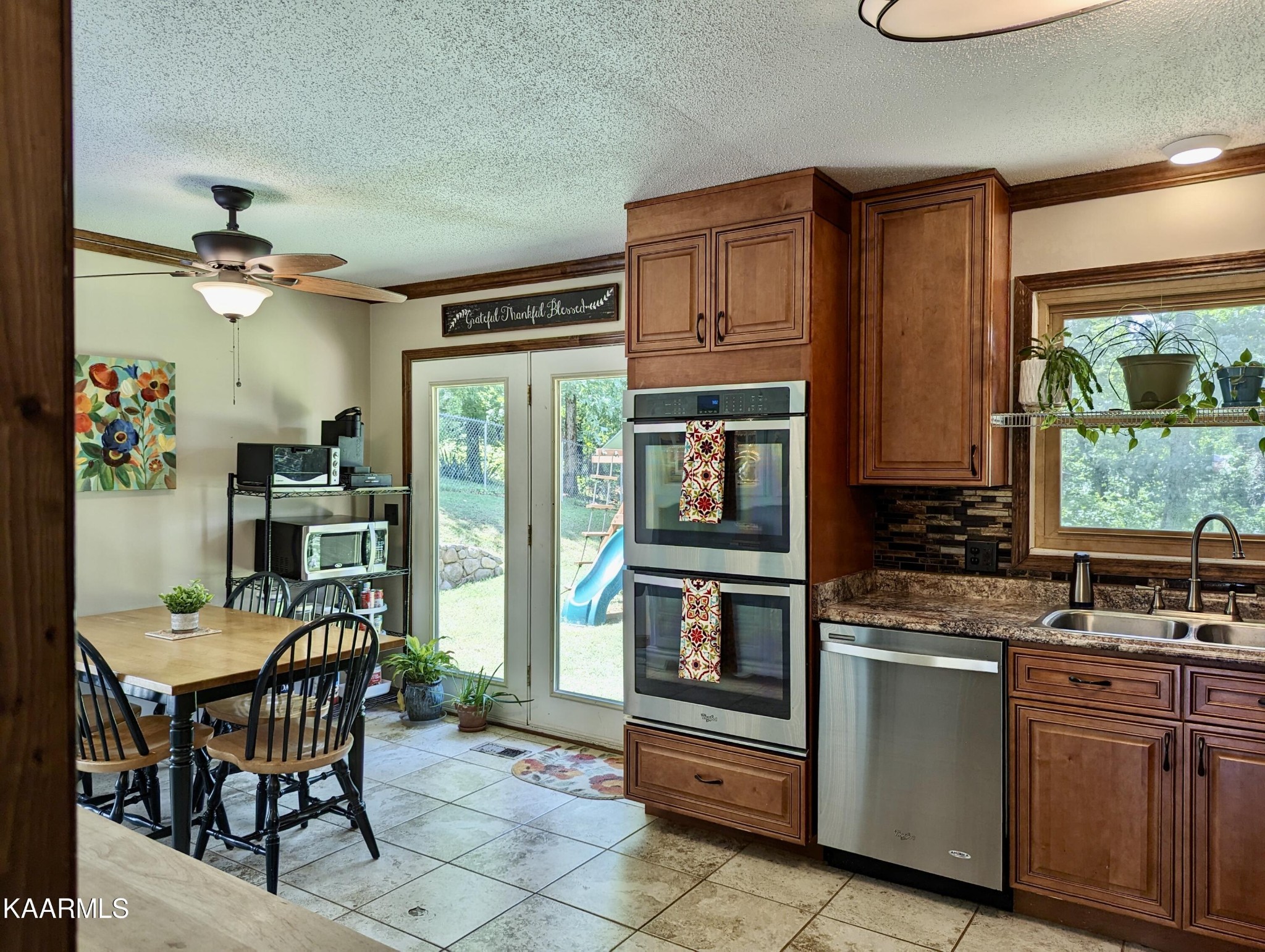 4518 Cloverdale Loop Hixson, TN 37343 - Photo 9 of 24 a kitchen with stainless steel appliances granite countertop a stove top oven a sink a dining table and chairs with wooden floor