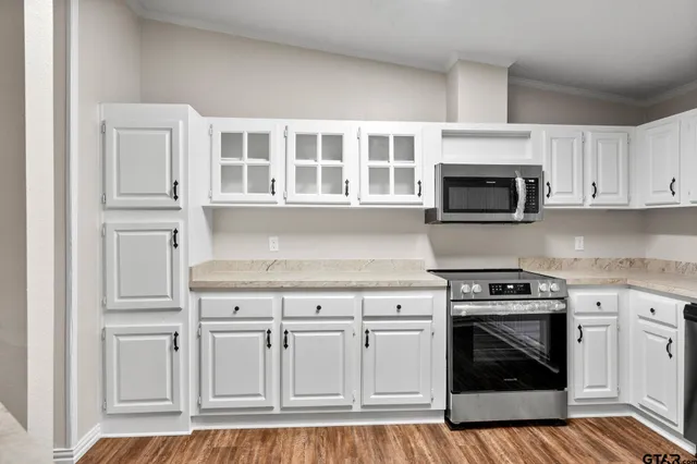 a kitchen with white cabinets and appliances