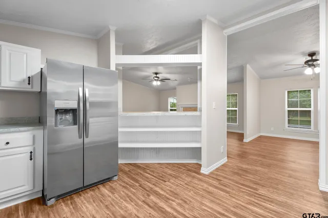 a view of a kitchen with wooden floor and electronic appliances