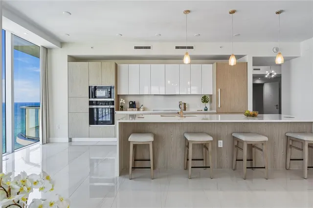 a kitchen with granite countertop white cabinets and refrigerator