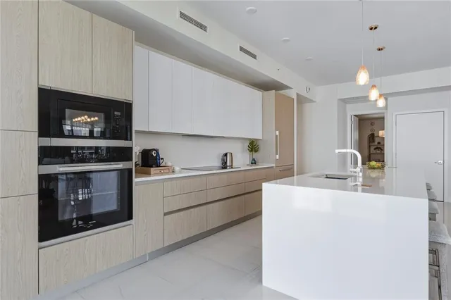 a kitchen with stainless steel appliances a stove a sink and a microwave