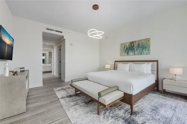 a spacious bedroom with a bed and a flat screen tv