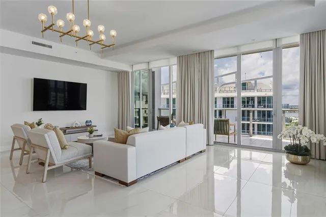 a living room with furniture chandelier and a flat screen tv