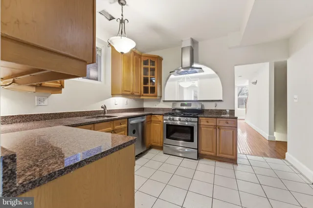 a kitchen with stainless steel appliances granite countertop a sink and stove top oven