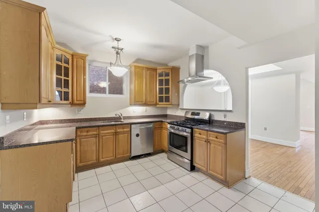 a kitchen with stainless steel appliances granite countertop a sink stove and cabinets