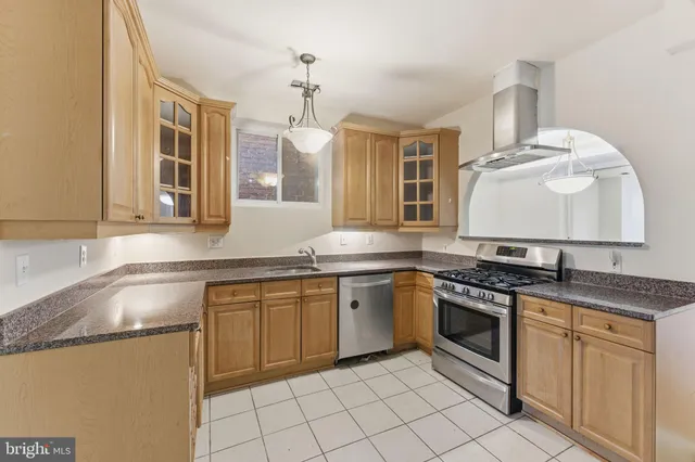 a kitchen with stainless steel appliances granite countertop a sink stove and cabinets