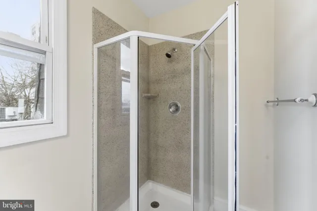 a view of an empty room with wooden floor and windows