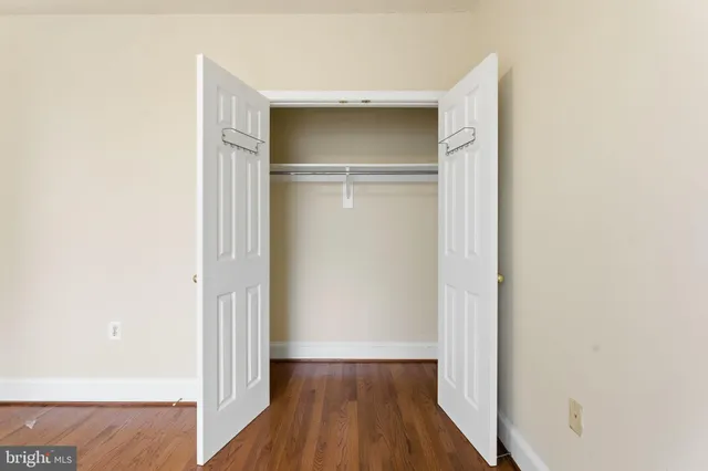 a view of an empty room with a window and closet area