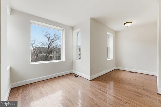 a view of an empty room with wooden floor